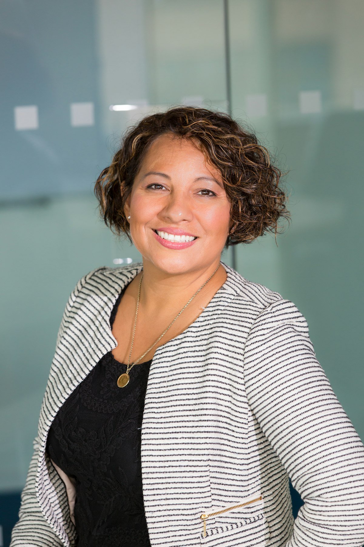 A smiling care professional standing in a bright modern workplace
